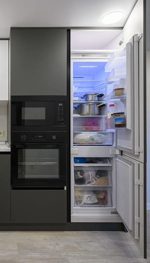 View of opened fridge freezer next to oven