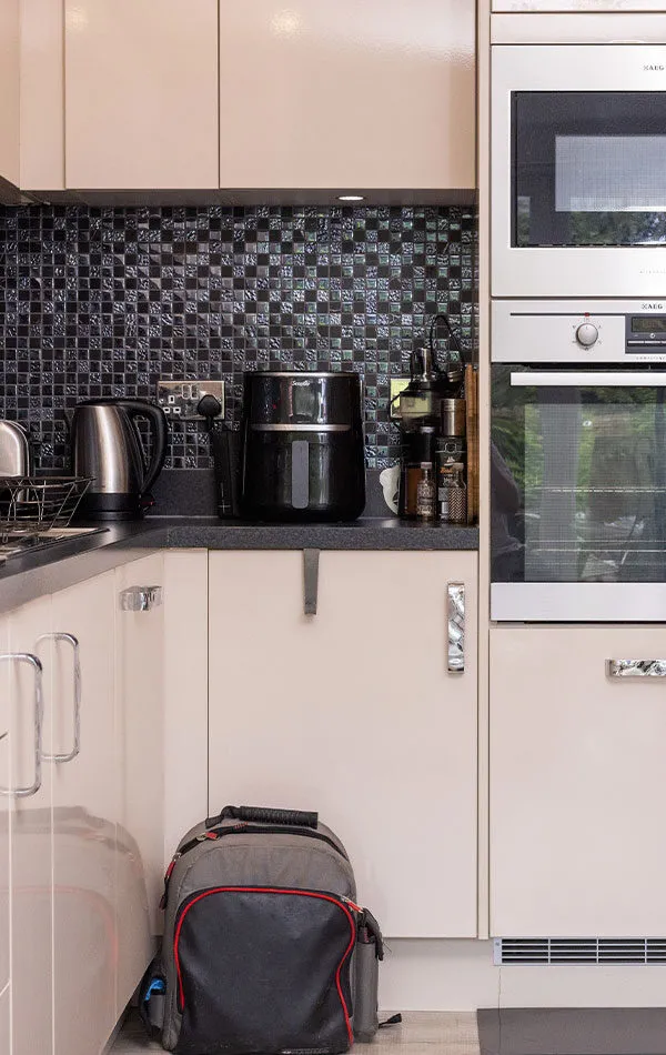 View of clean kitchen with white cupboards