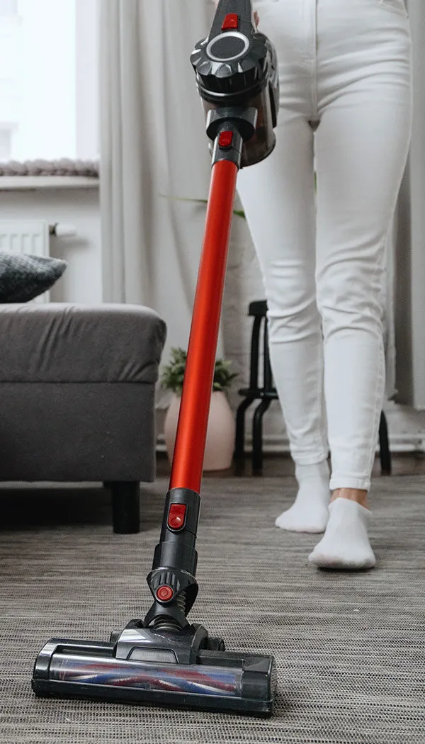 Woman in white jeans vacuuming with cordless vacuum